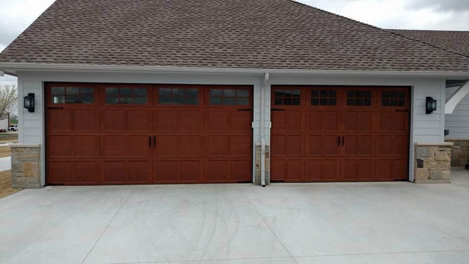 There are two garage doors on the side of a house.