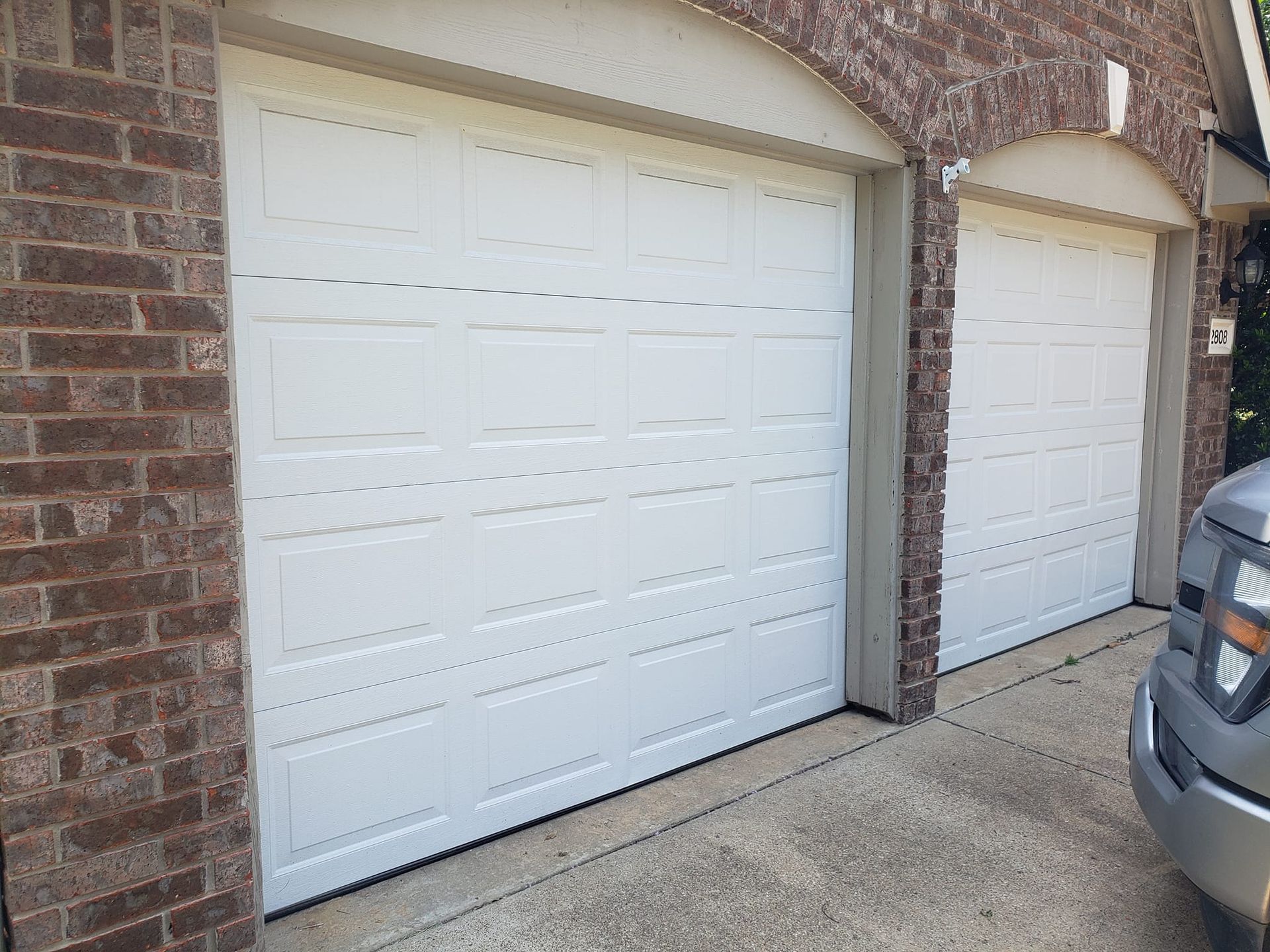 A truck is parked in front of a garage door.