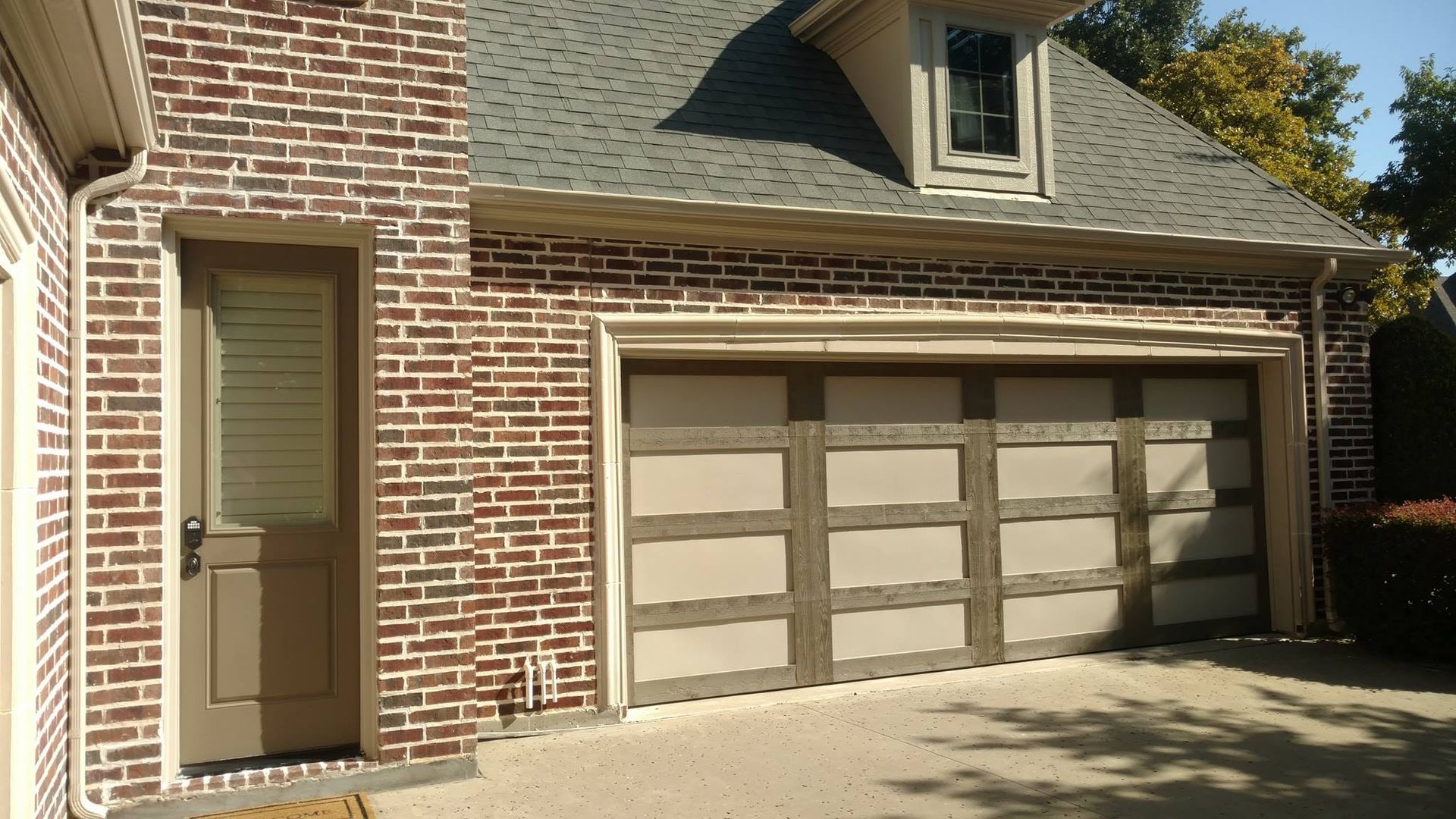 A brick house with a garage and a door.