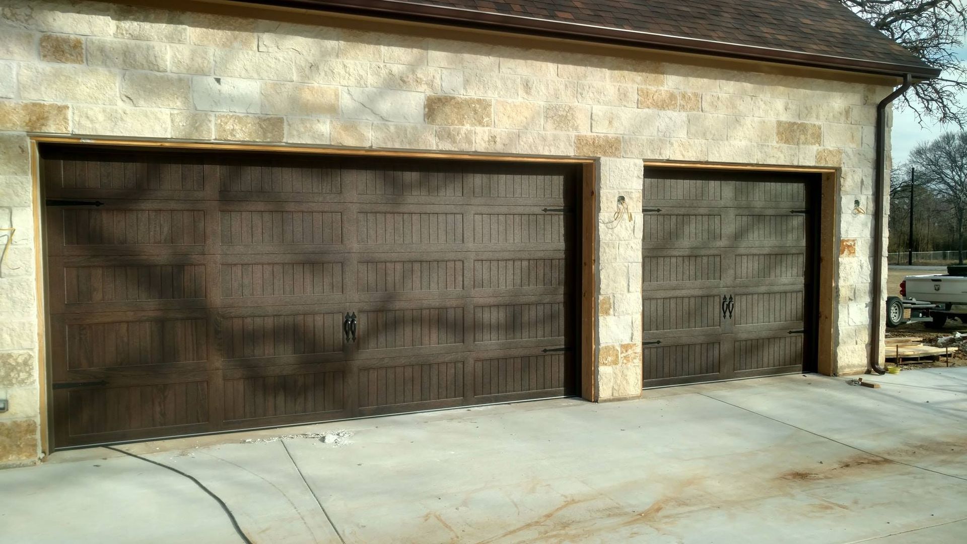 There are three garage doors on the side of a building.