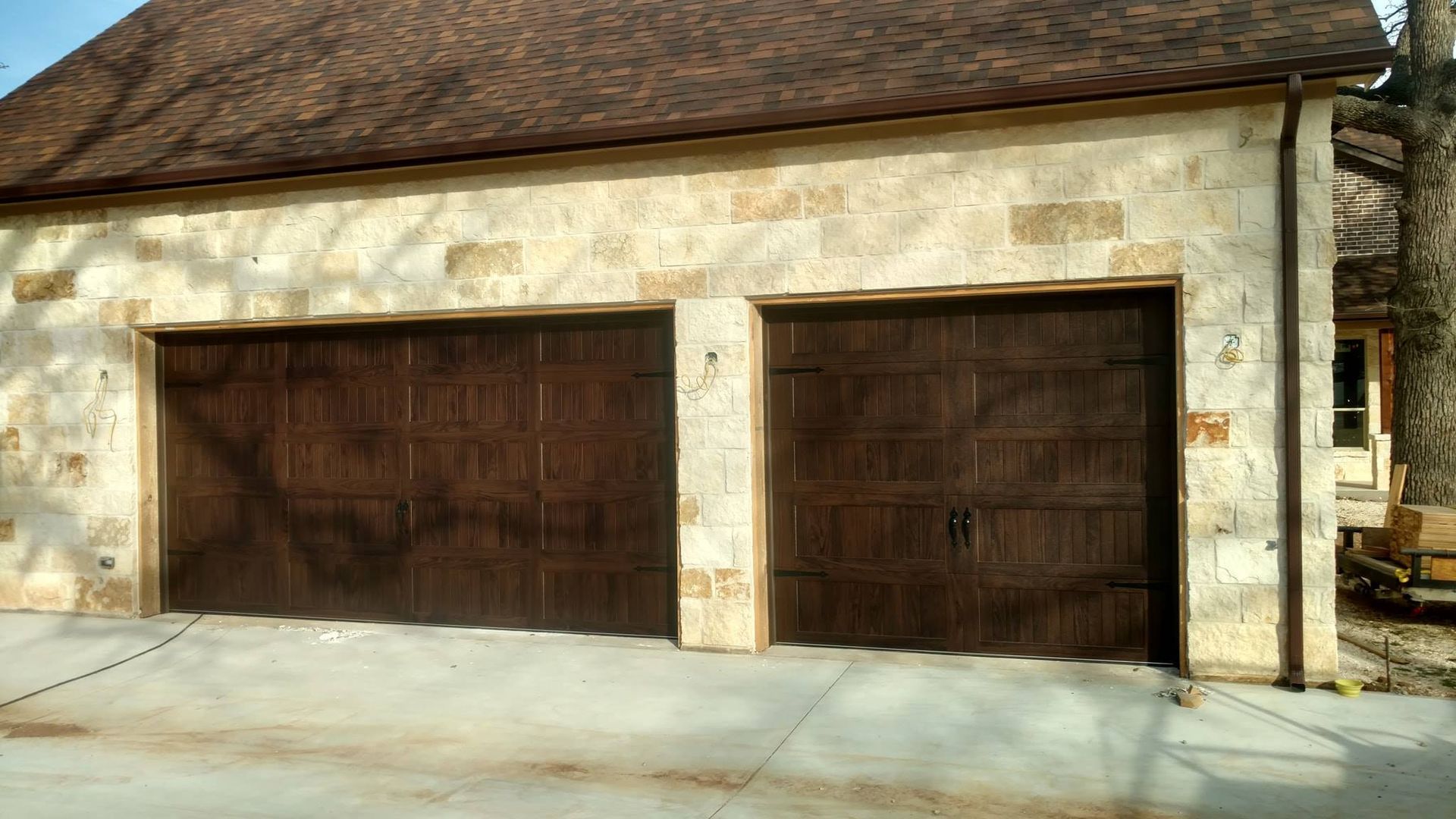 There are two garage doors on the side of a house.