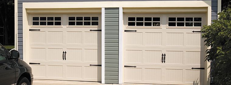 A car is parked in front of a white garage door.