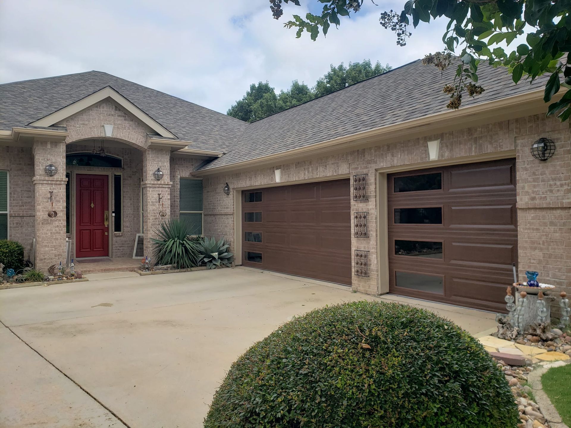 A house with two garage doors and a red door.