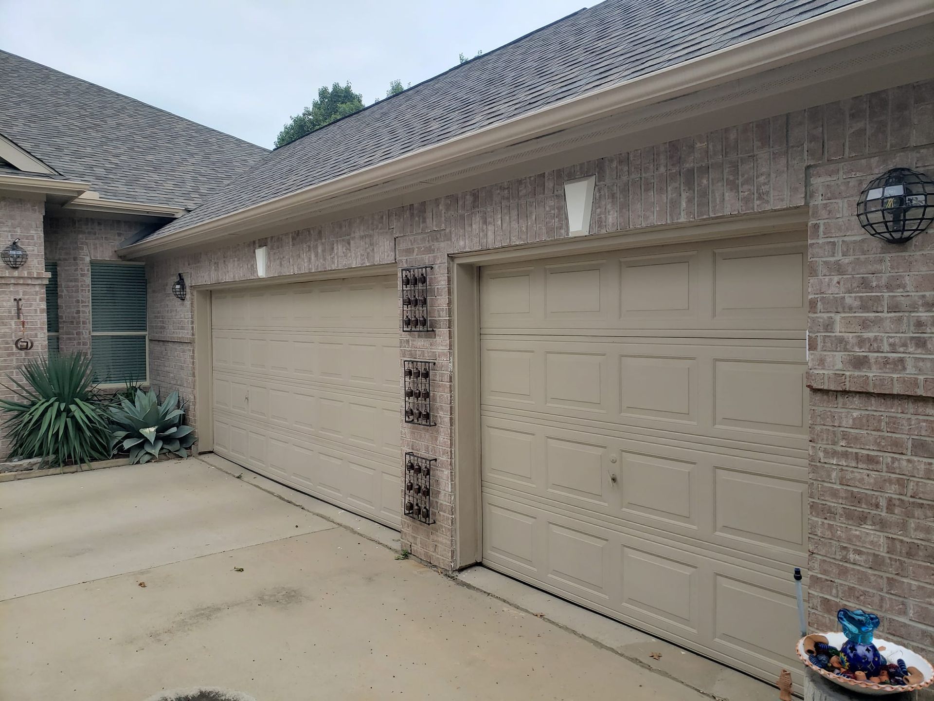 There are two garage doors on the side of a house.