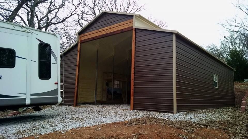 A trailer is parked in front of a metal garage.