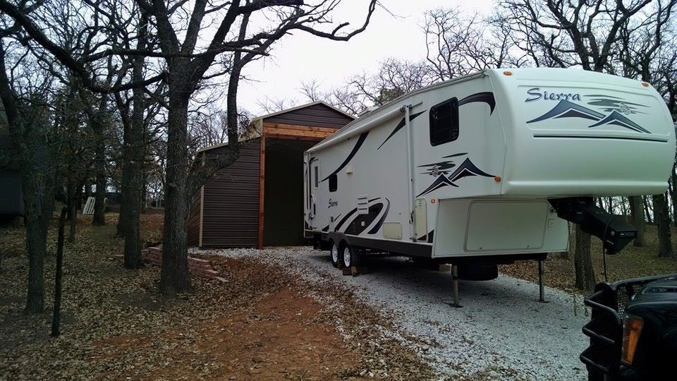 A white rv is parked in front of a garage