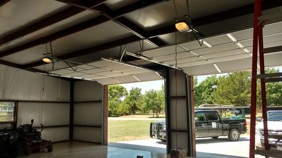 A truck is parked in a garage with the door open.