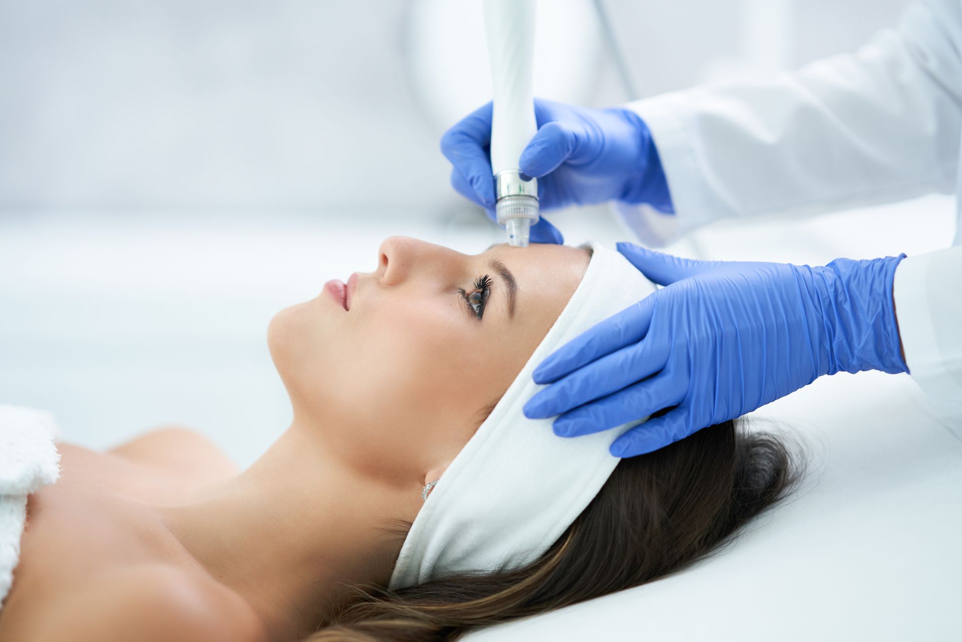 A woman is getting a facial treatment at a beauty salon.
