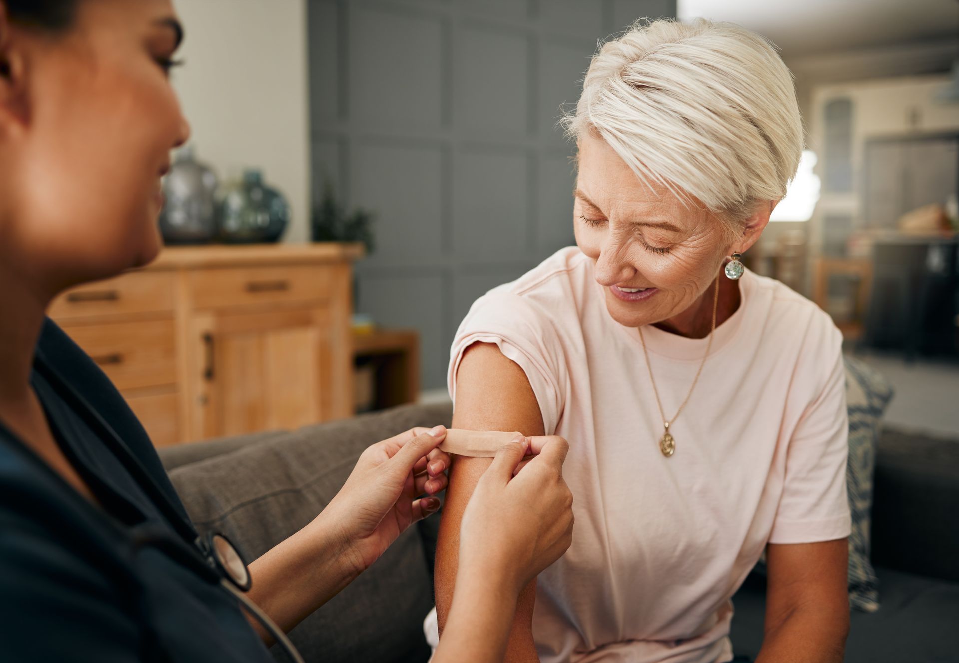 A woman is getting a vaccine from a nurse.