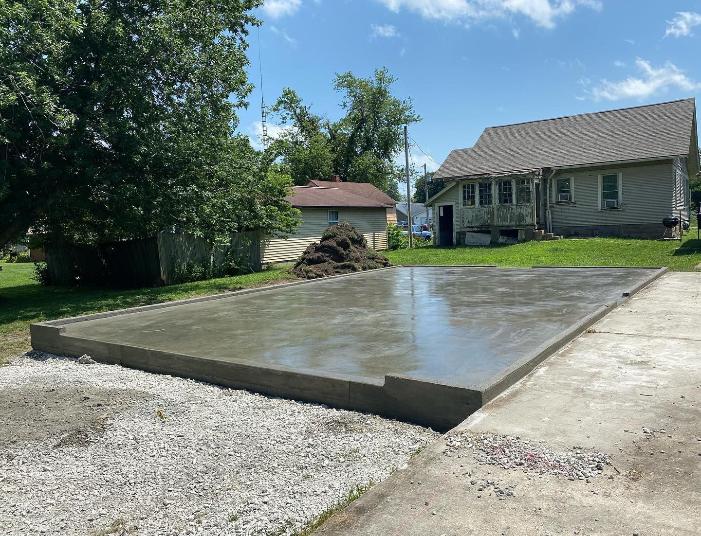 Person using a squeegee to clean a window, streaks of water and bubbles visible.