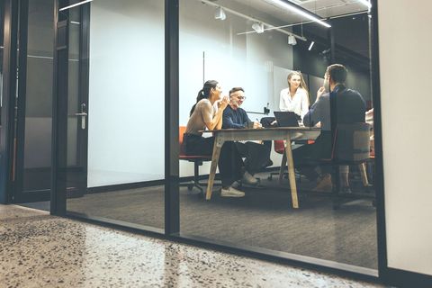 A group of people are sitting around a table in a conference room.