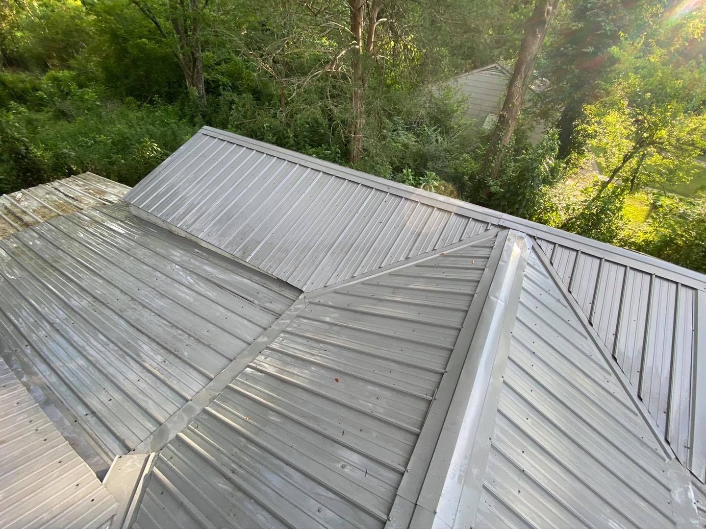 An aerial view of a metal roof with trees in the background.