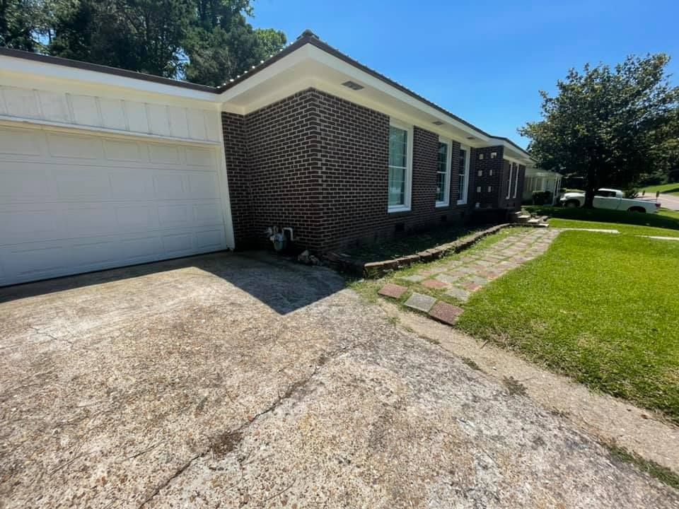 A brick house with a white garage door and a driveway.