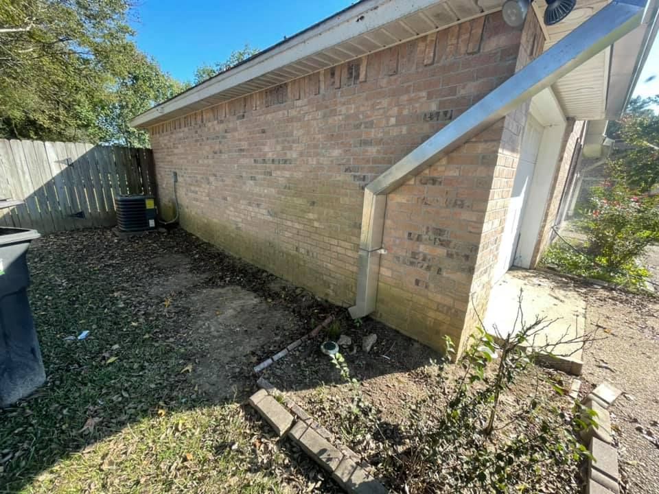 A brick house with a gutter on the side of it.
