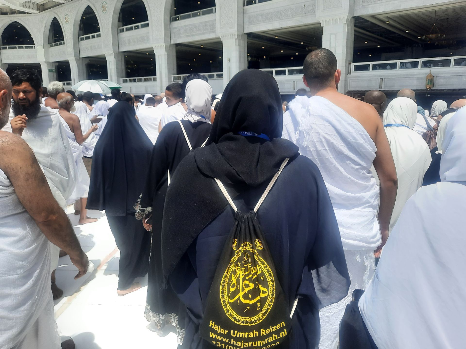 Een vrouw die een zwarte rugzak draagt ​​met Arabische letters erop