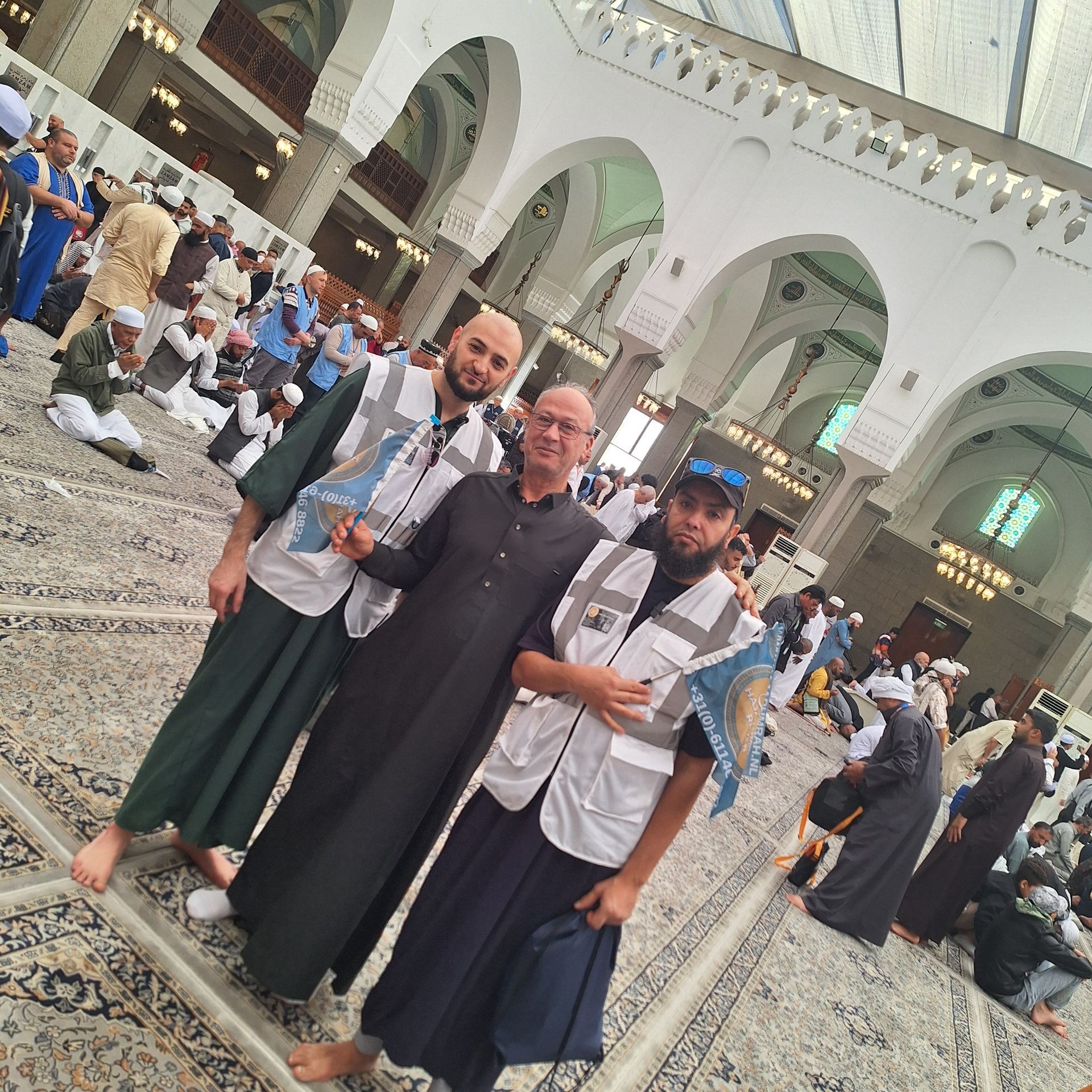Een groep mannen poseert voor een foto in een moskee
