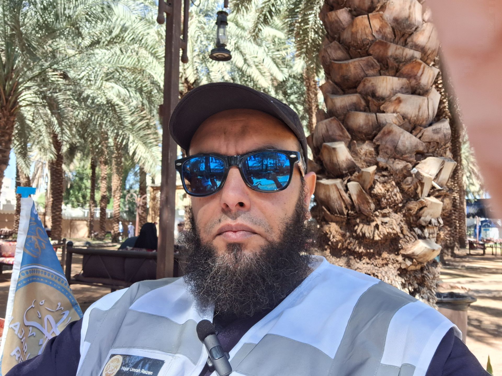 Een man met een baard, een zonnebril en een hoed