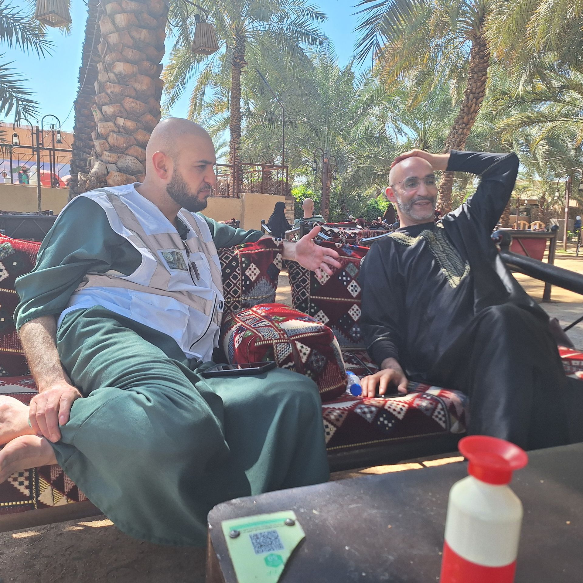 Twee mannen zitten op een bank met elkaar te praten