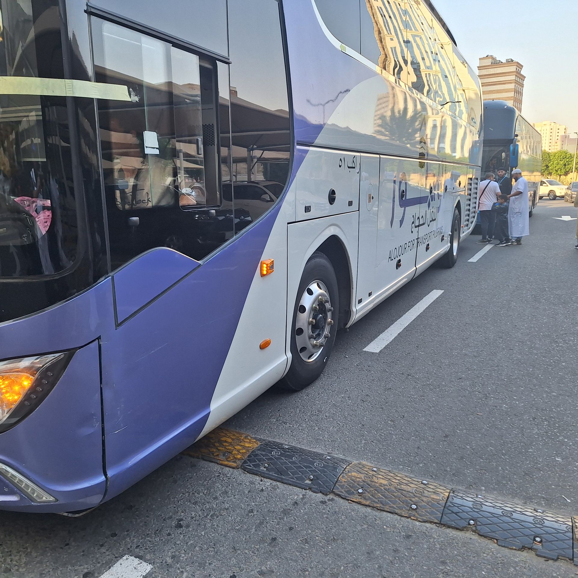 Een paars-witte bus staat geparkeerd aan de kant van de weg