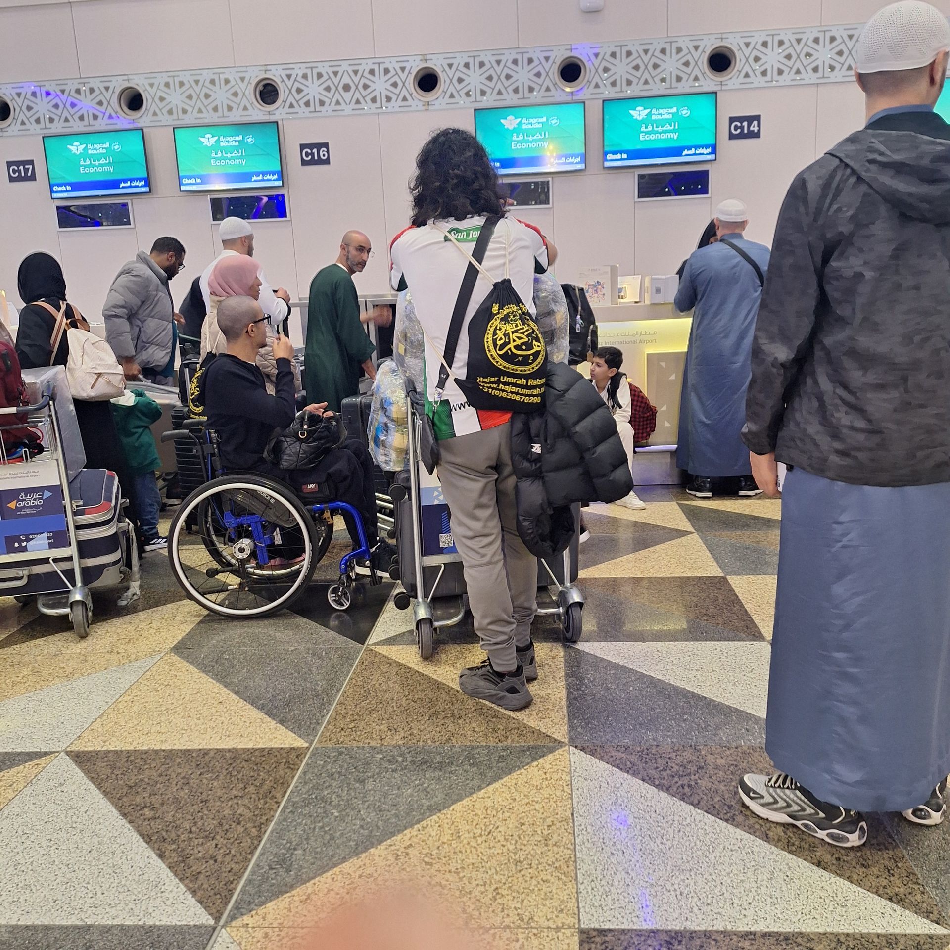 Een man in een rolstoel staat in een rij met andere mensen