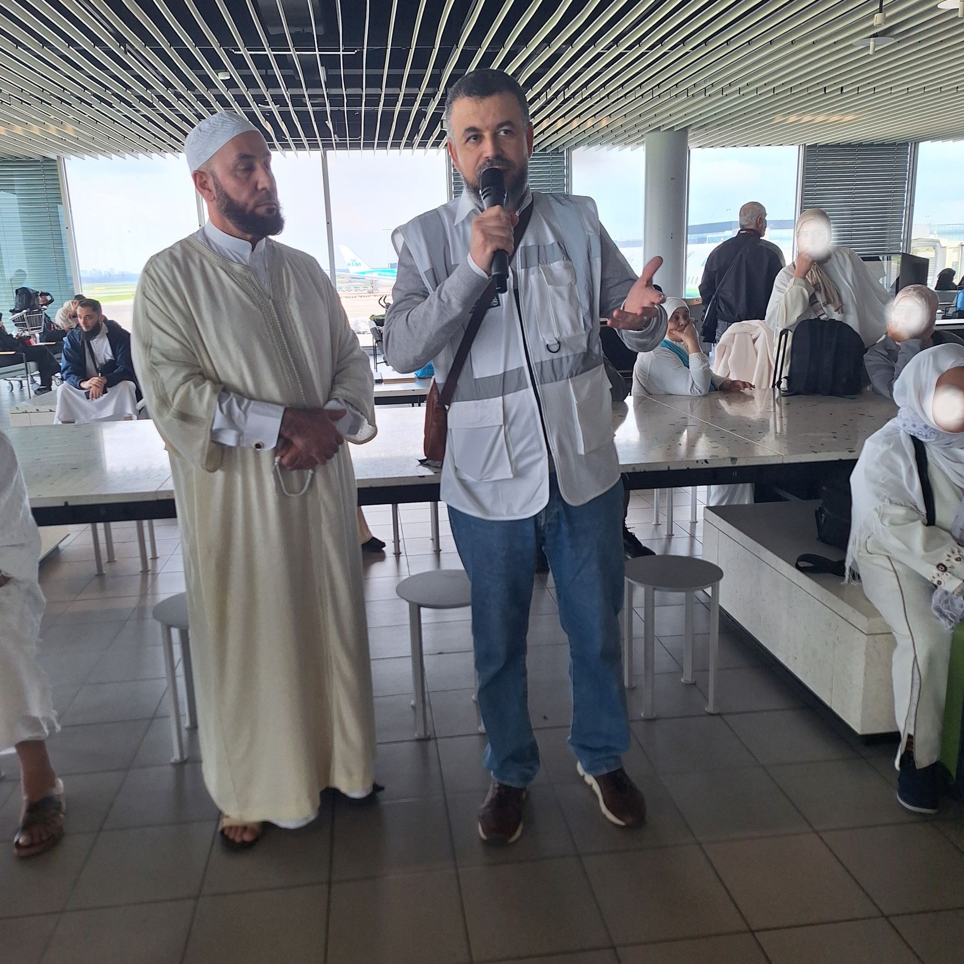 Een man die in een microfoon spreekt voor een groep mensen