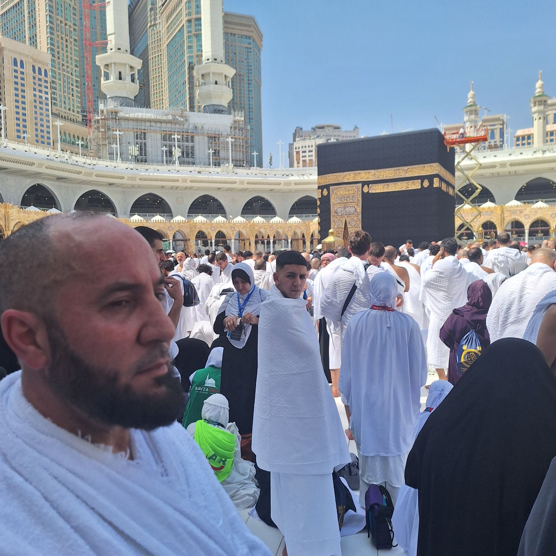 Een man met een baard staat voor een menigte mensen