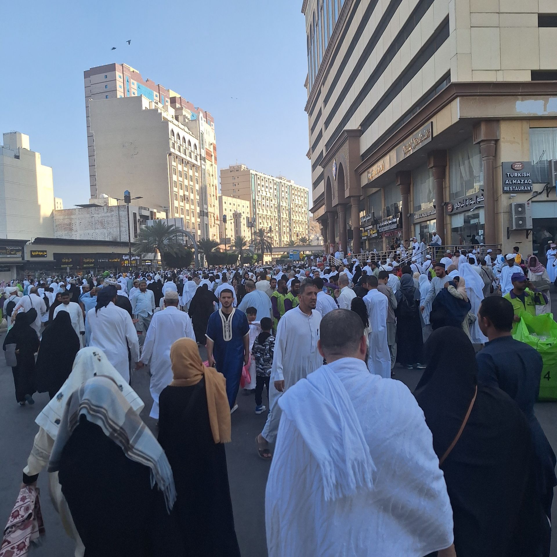 Een grote groep mensen loopt over straat voor een gebouw met de tekst 'ijs'