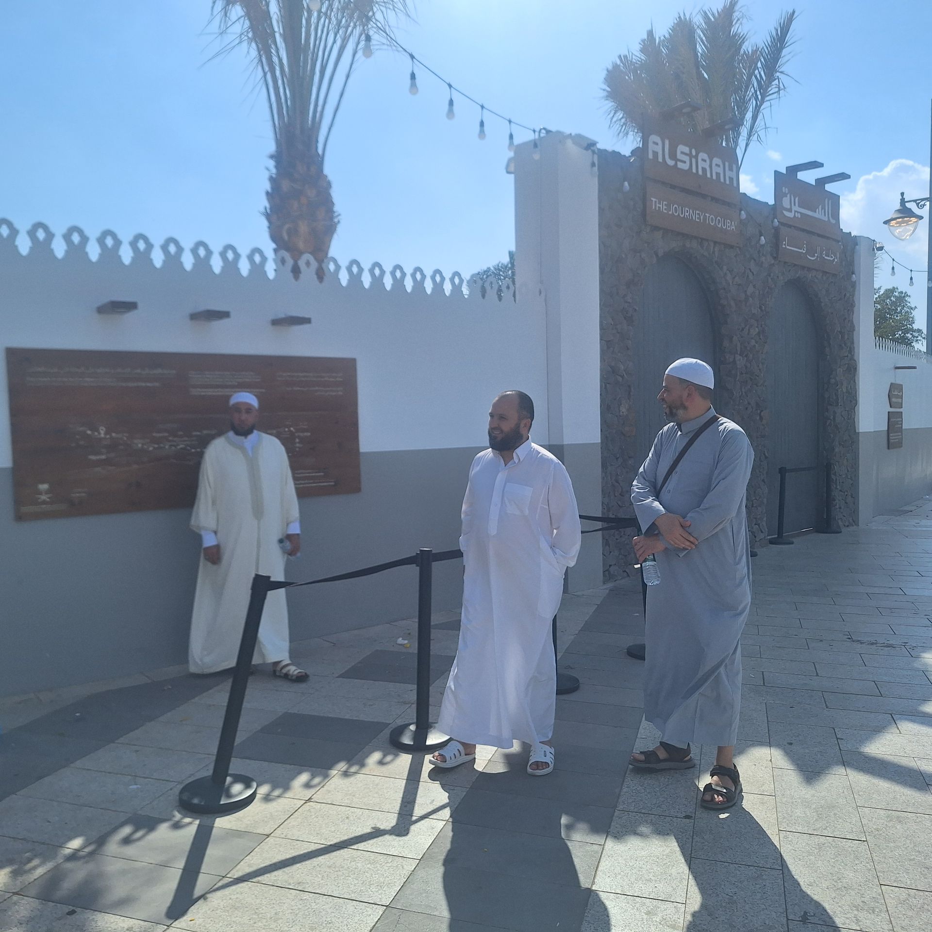 Drie mannen staan ​​voor een gebouw met de tekst aleiar