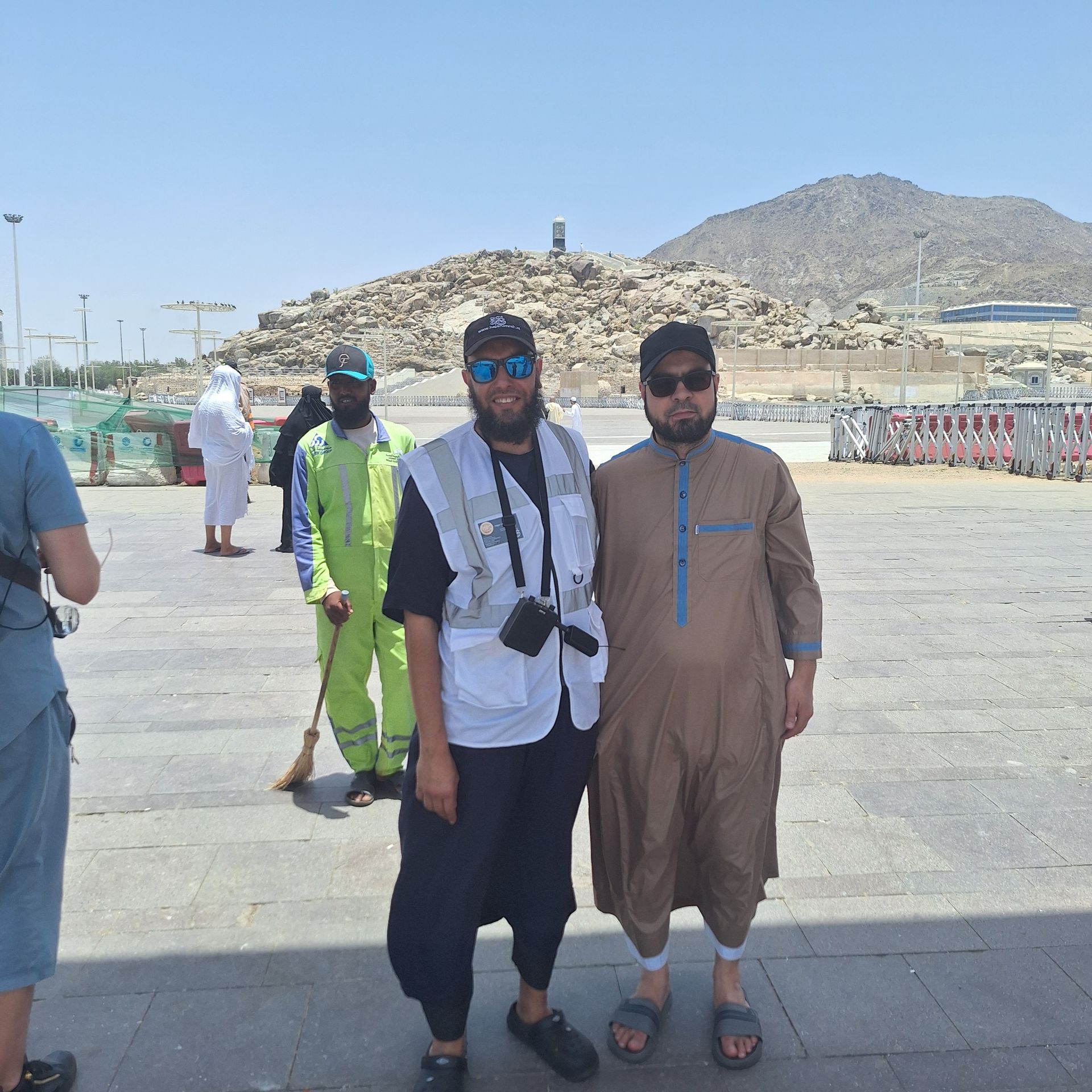 Twee mannen poseren voor een foto met bergen op de achtergrond