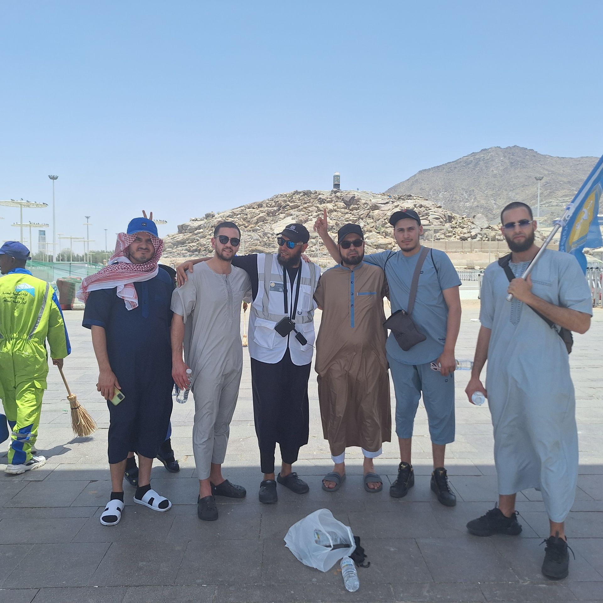 Een groep mannen poseren voor een foto met bergen op de achtergrond