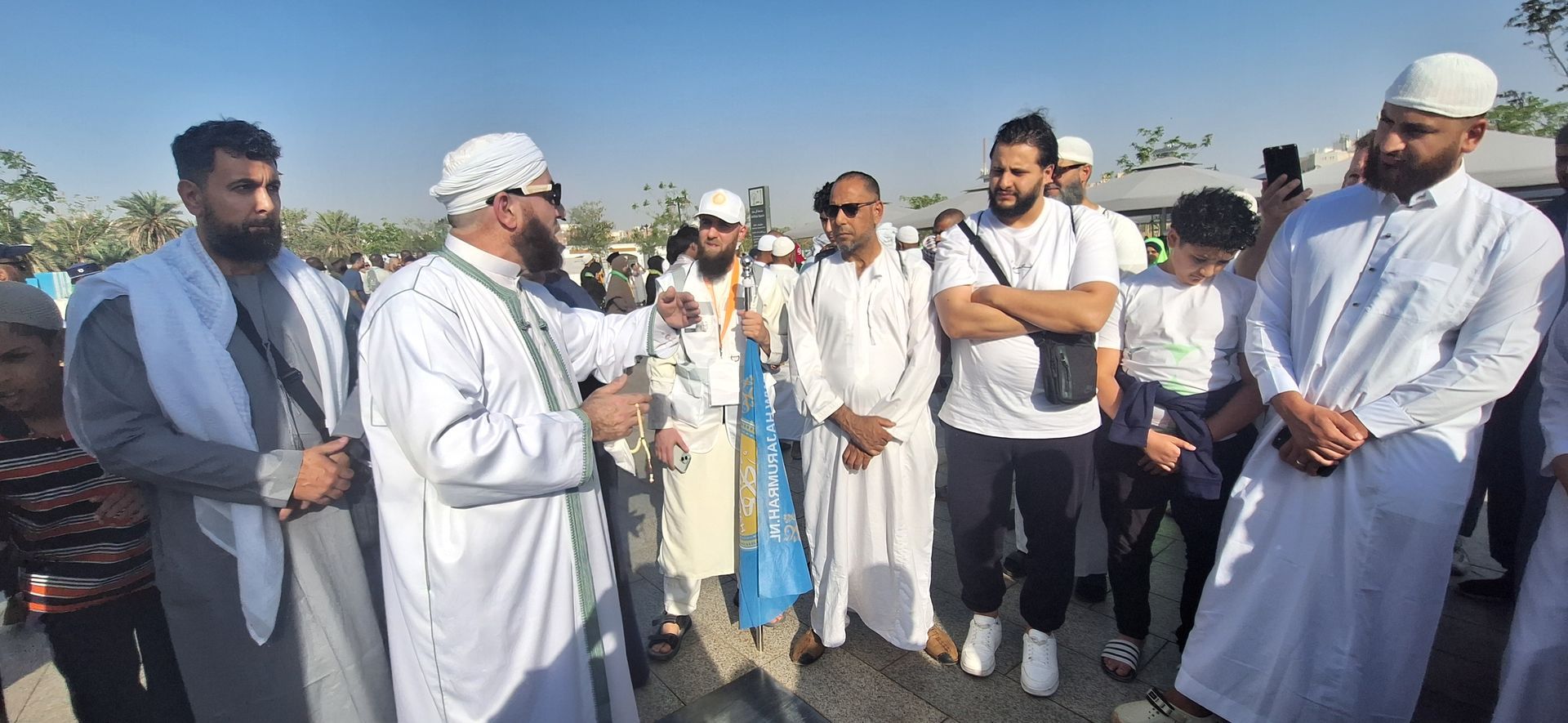 Een groep mannen in witte gewaden staat naast elkaar.