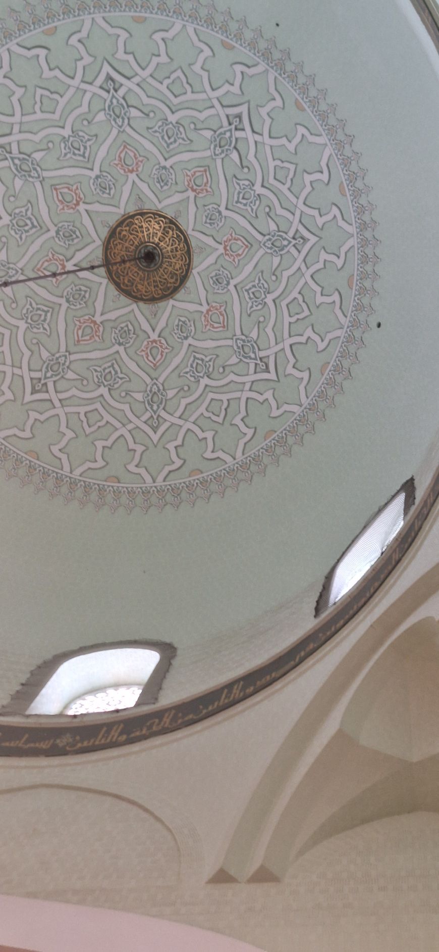 Een close-up van het plafond van een gebouw met een cirkelvormig ontwerp erop.