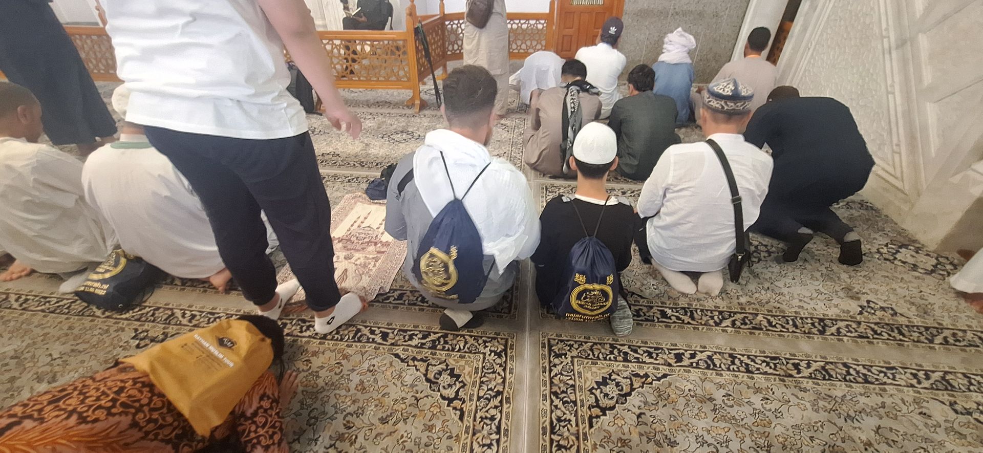 Een groep mensen knielt in een moskee.