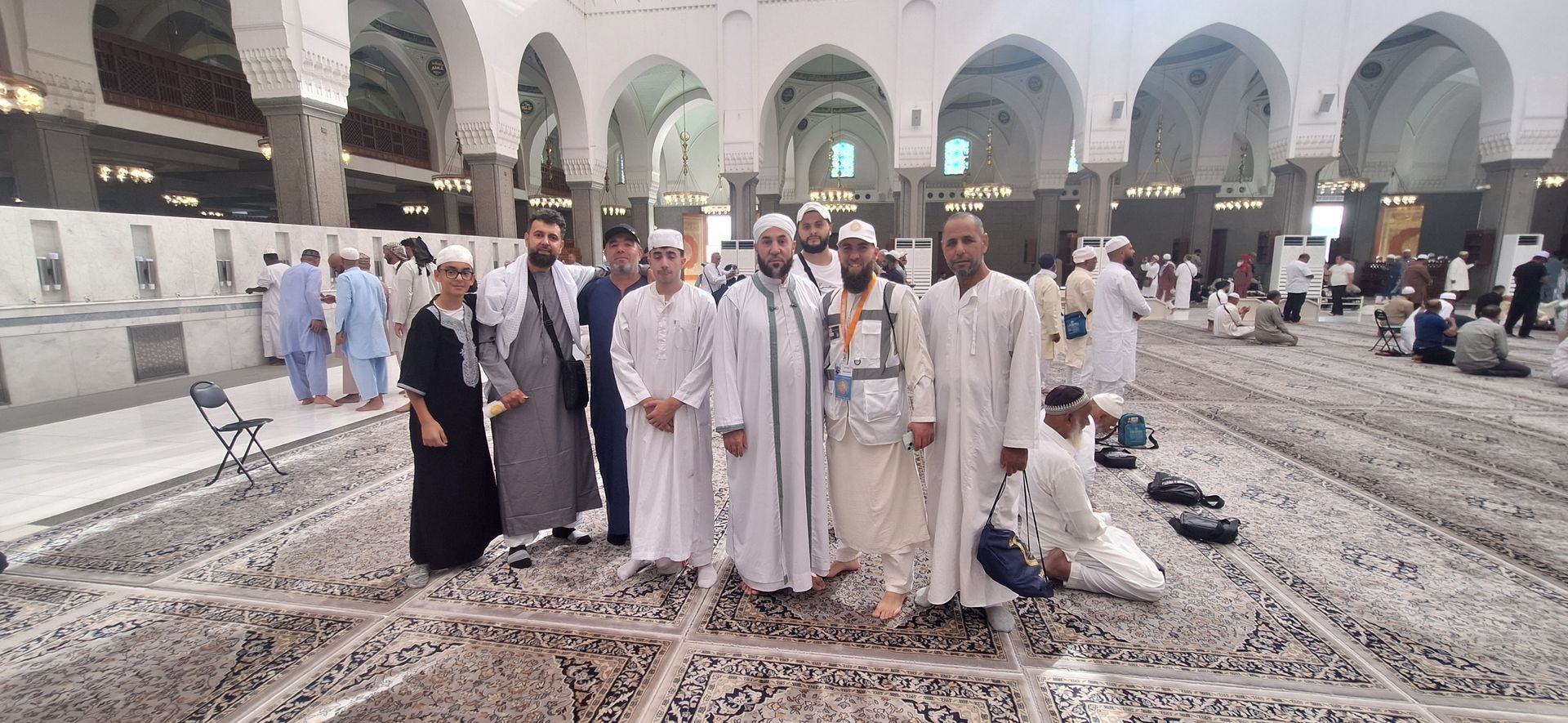 Een groep mensen poseert voor een foto in een moskee.