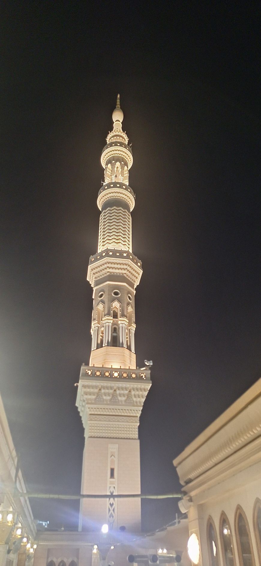 's Nachts wordt een hele hoge toren voor een gebouw verlicht.