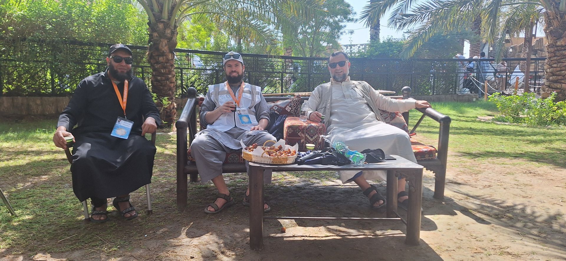Drie mannen zitten op een bank in een park.