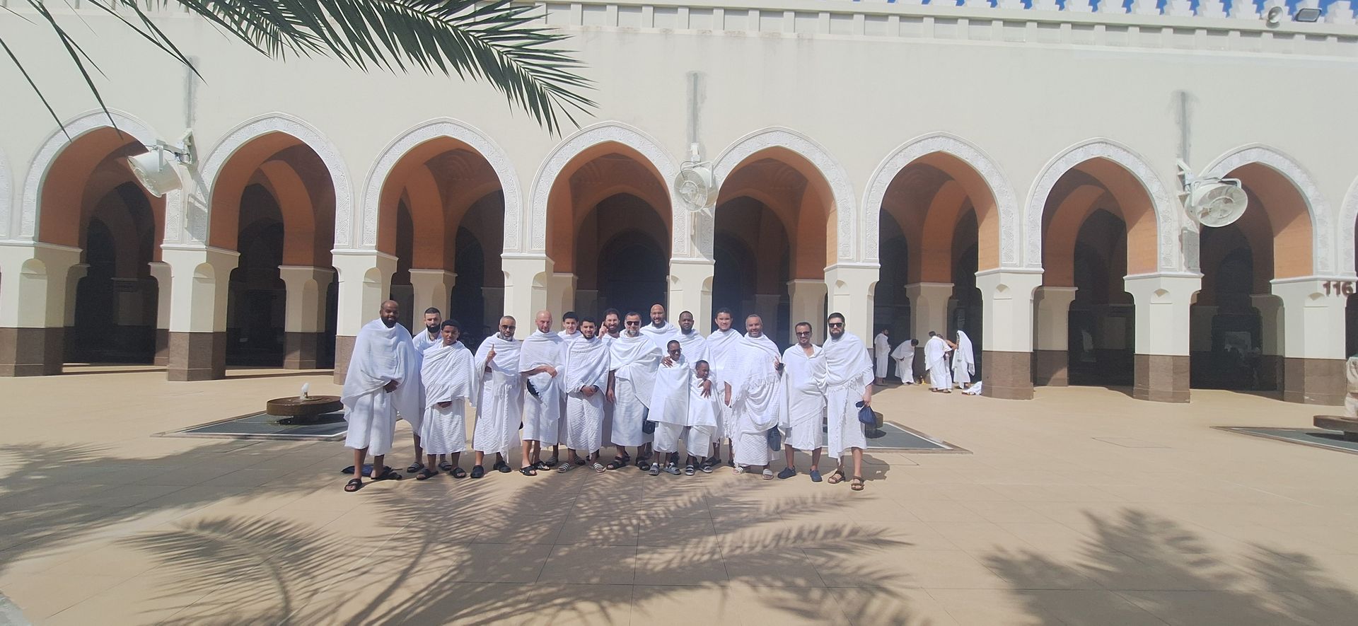 Een groep mensen die voor een gebouw met bogen staat