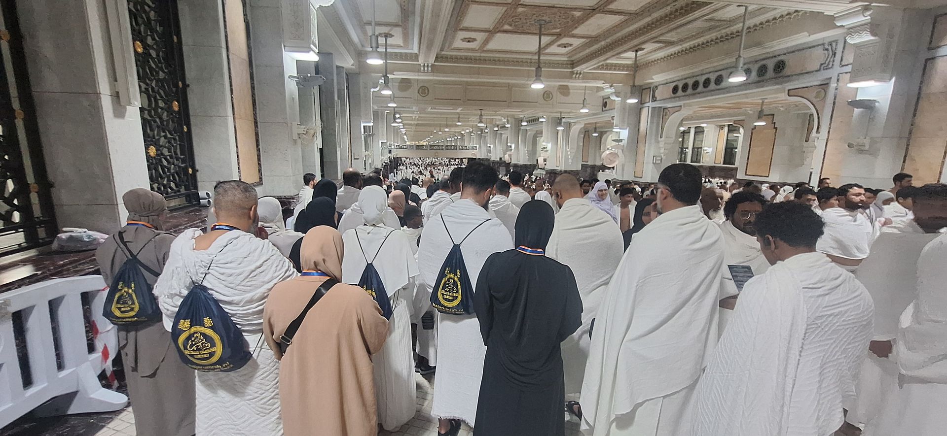 Een grote groep mensen staat in een moskee.