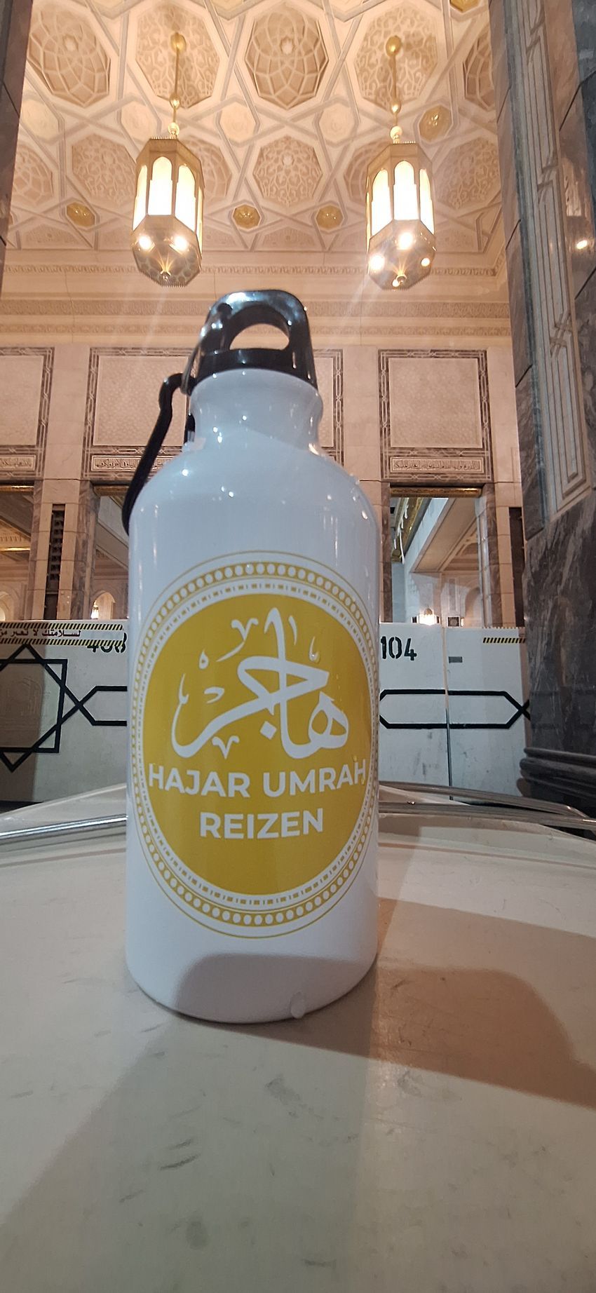 Een fles water staat op een tafel in een moskee.