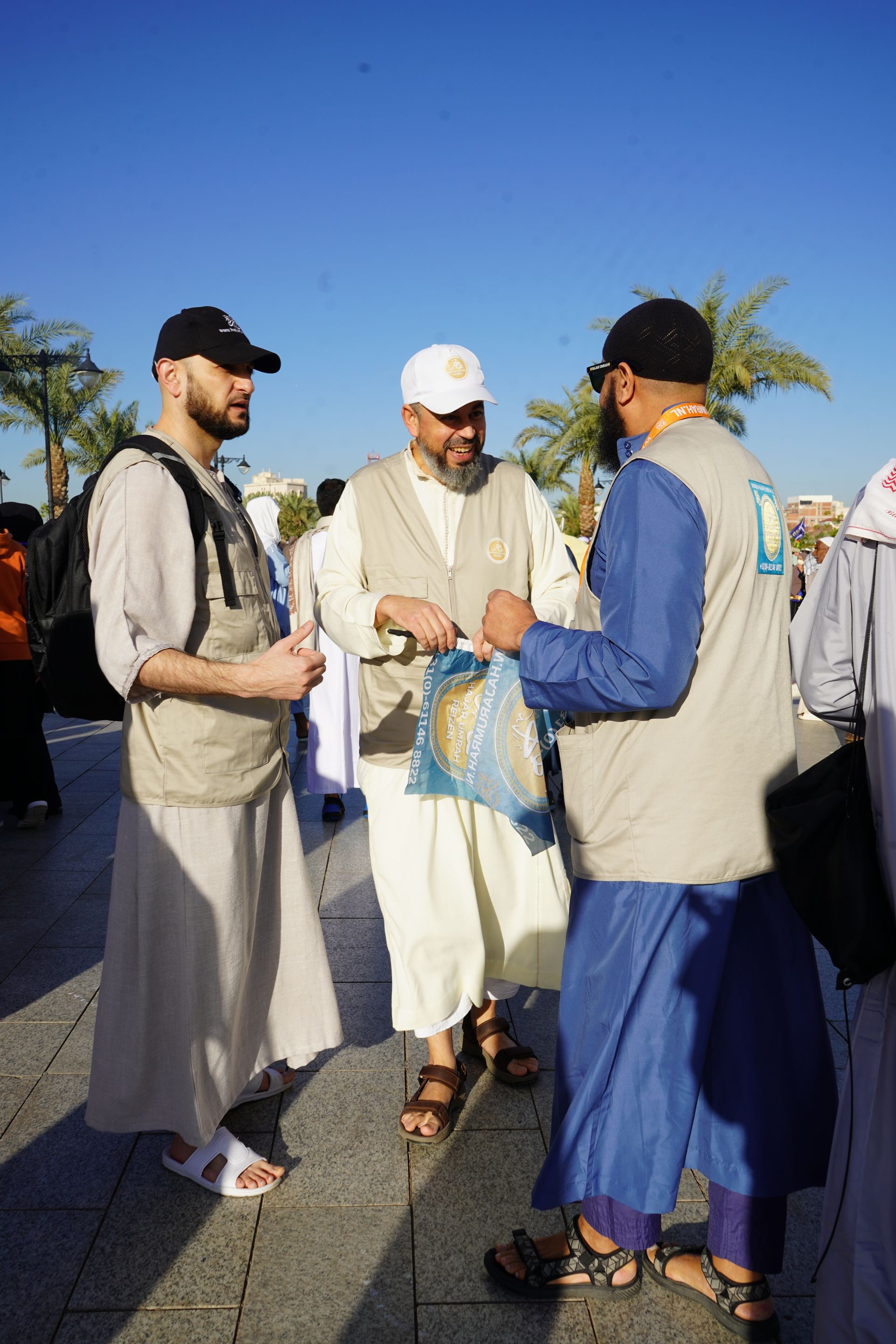 Een groep mannen staat op de stoep met elkaar te praten.