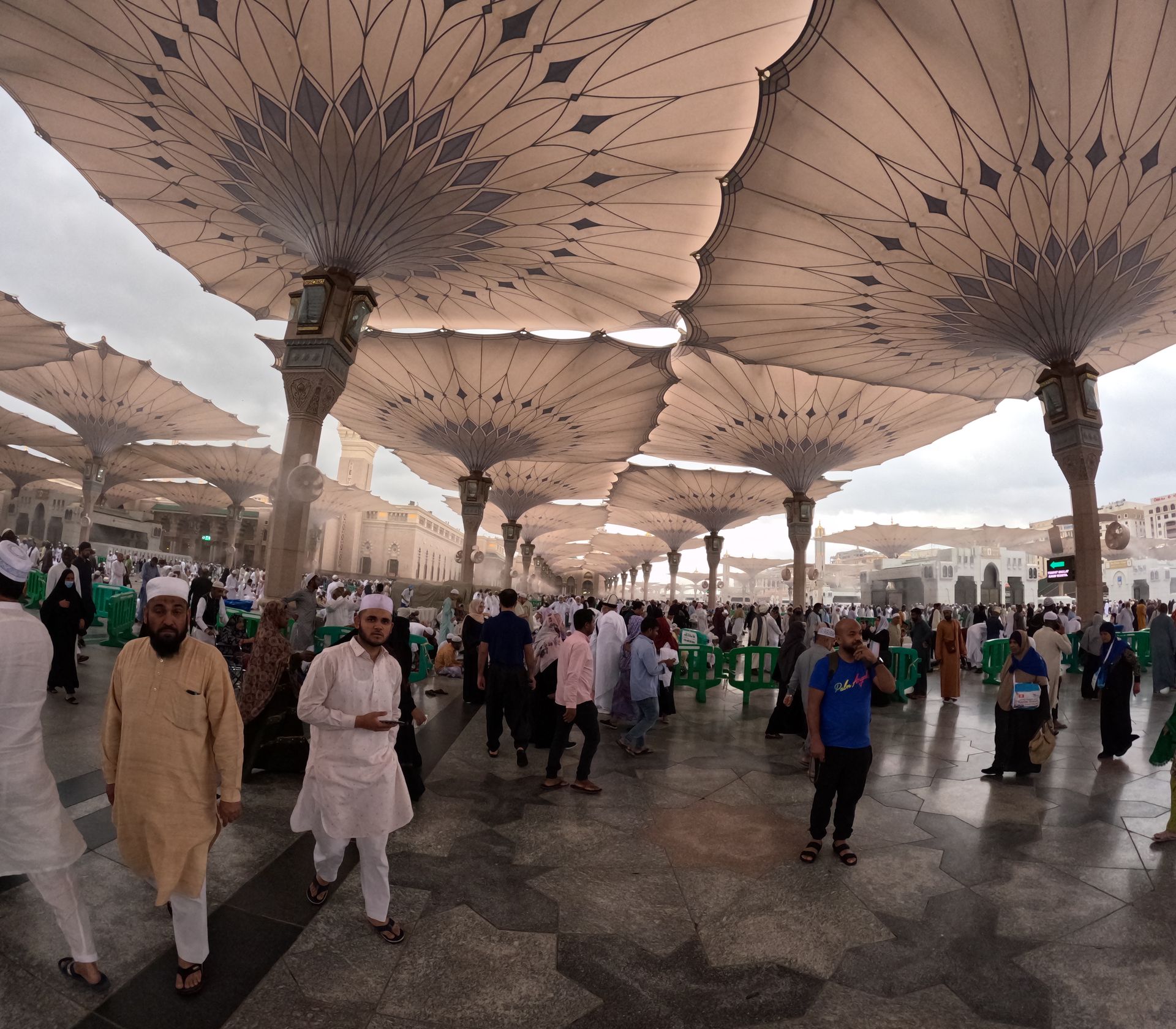 Een groep mensen loopt onder grote paraplu's