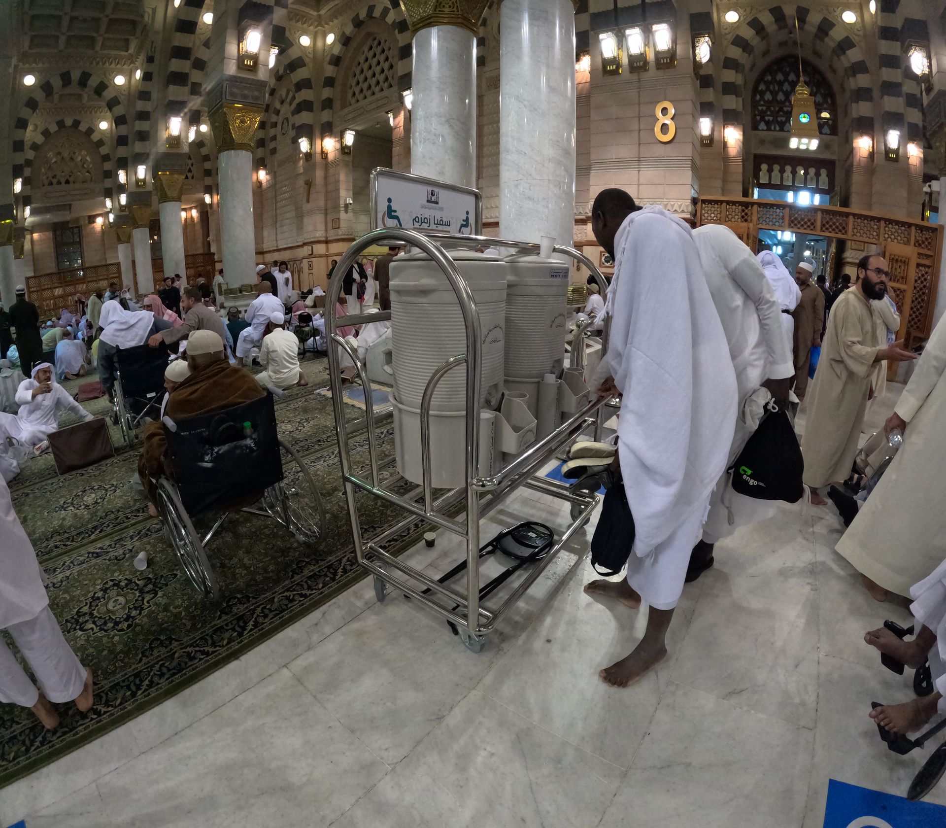 Een groep mensen staat rond een kar met een bordje waarop 8 staat