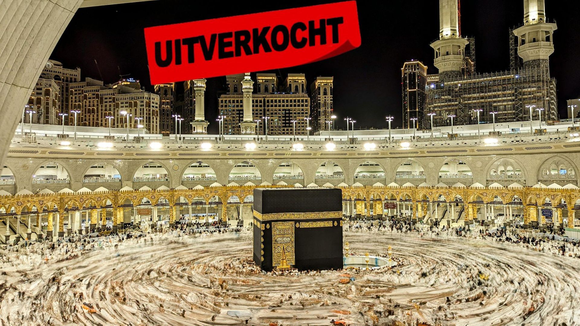 's Nachts wordt de Kaäba omringd door een menigte mensen in een moskee.