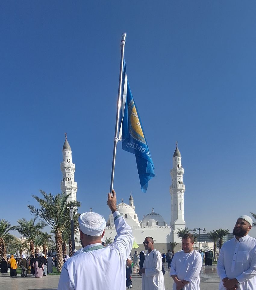 Een man houdt een blauw-gele vlag vast voor een moskee