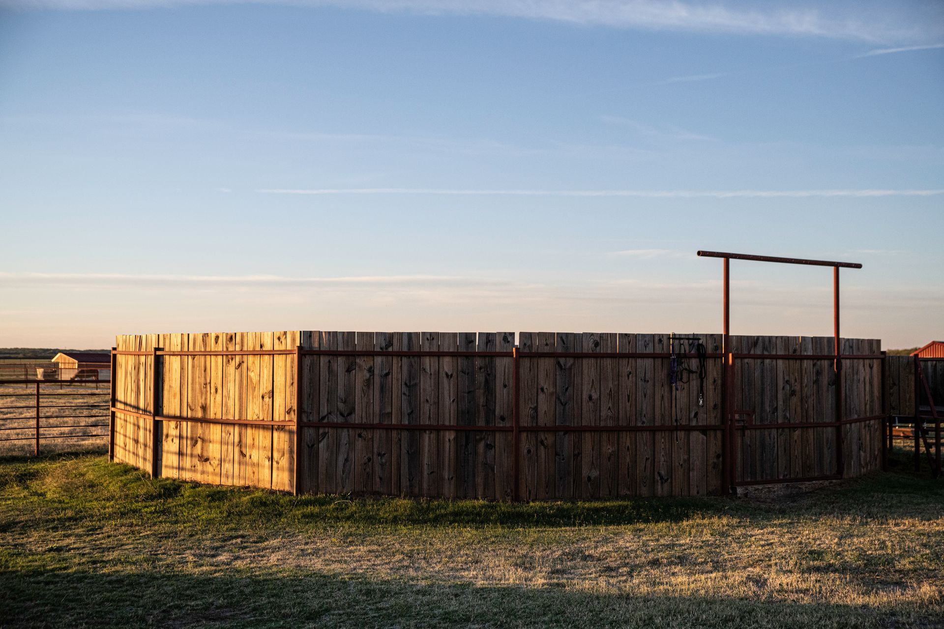 there is a wooden fence in the middle of a field .