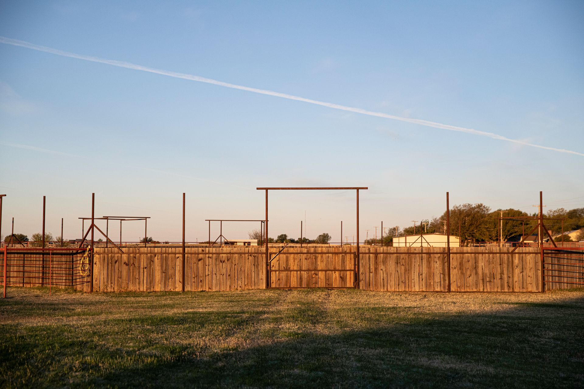 there is a wooden fence in the middle of a field .