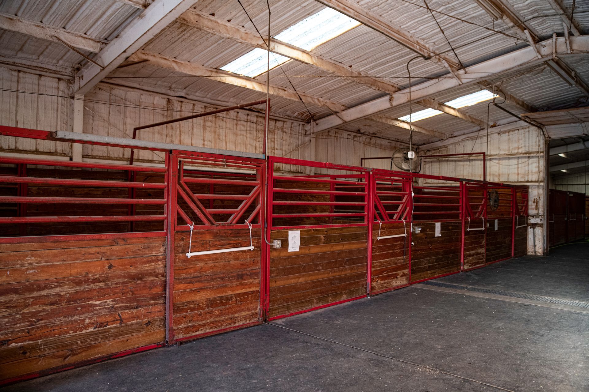 a row of wooden horse stalls in a barn .