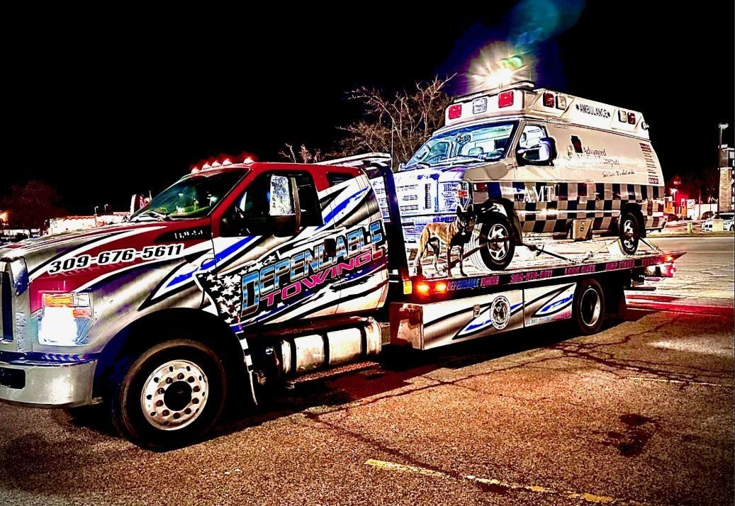 A tow truck with an ambulance on the back of it.