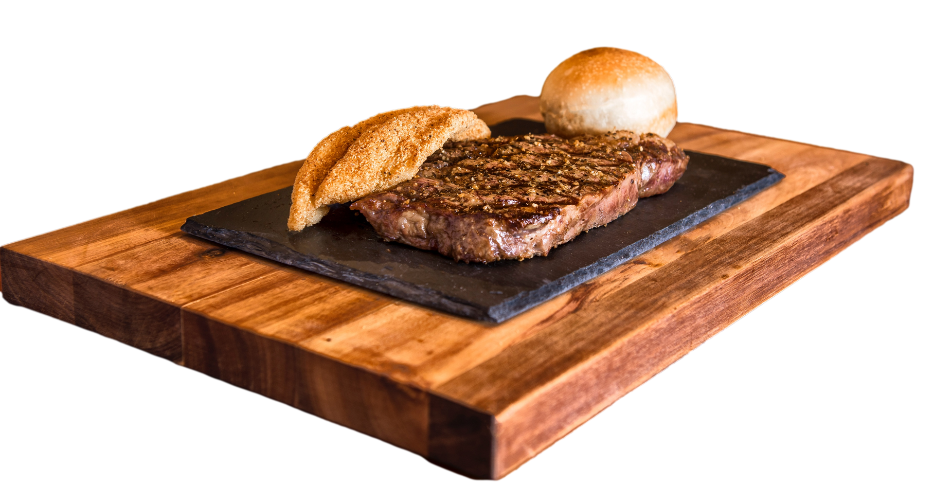 A steak and a bun are on a wooden cutting board.