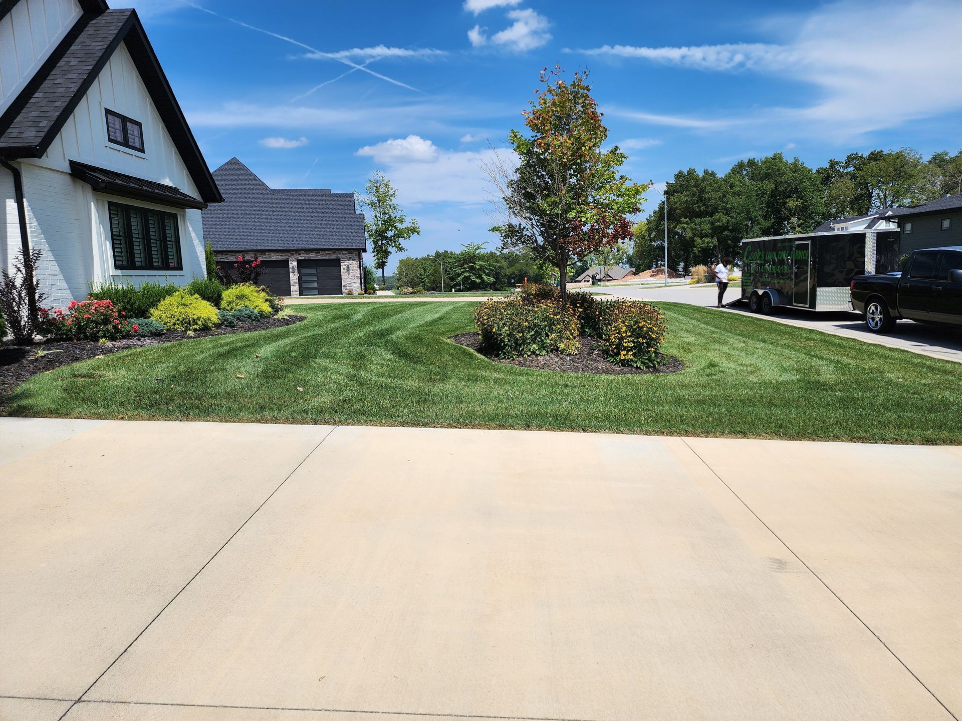 A white house with a lush green lawn in front of it.